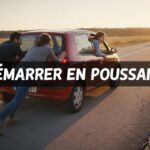 Deux personnes poussent une voiture compacte sur une route en pente avec un conducteur au volant et le texte Démarrer en poussant en surimpression.